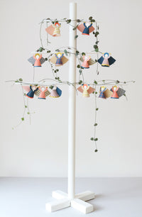 Decorative stand with hanging angel figures and lights on a white background