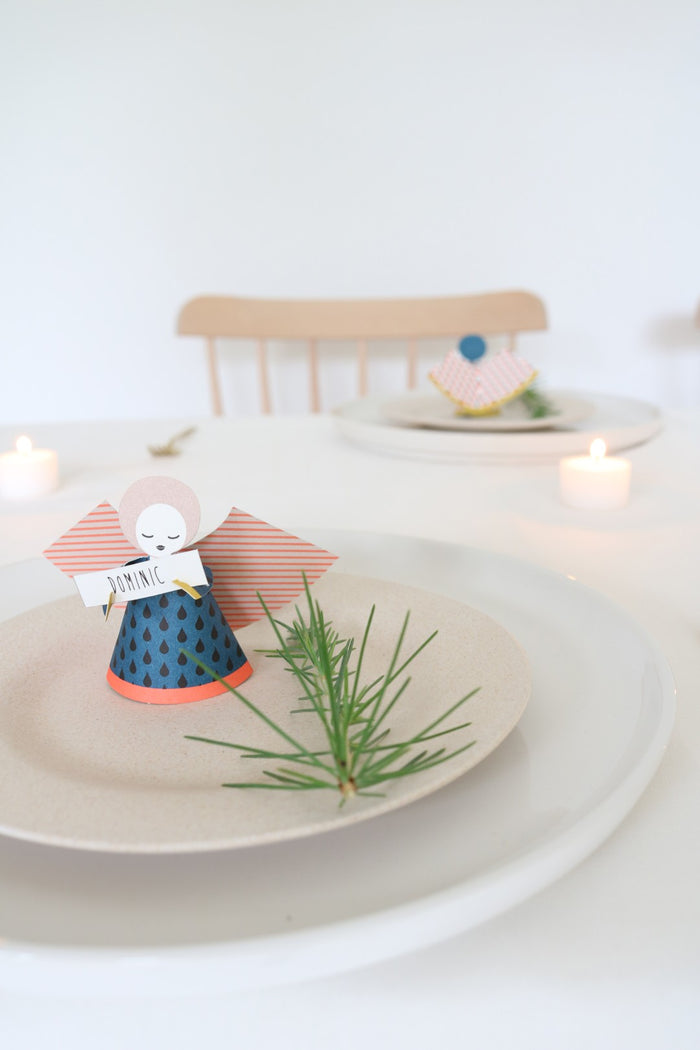 Decorative angel figurine on a plate with a white background