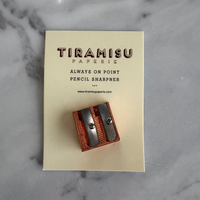 Tiramisu Papière pencil sharpener on a beige card with marble background