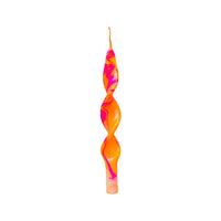 Colorful twisted candle on a light gray background