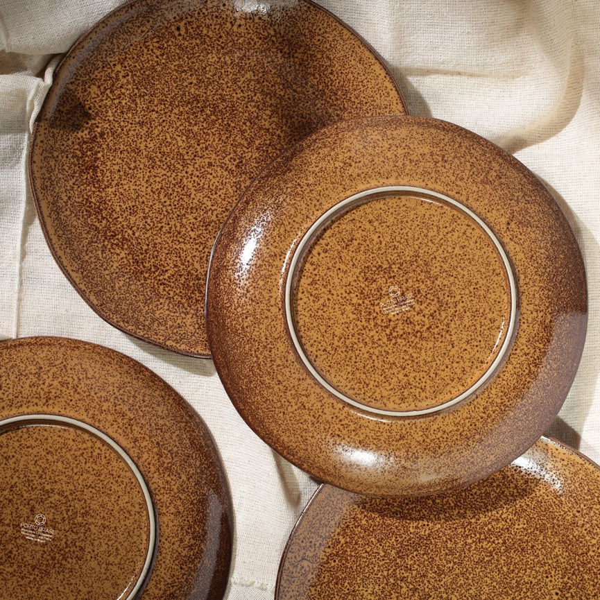 Set of brown ceramic plates on a light fabric background