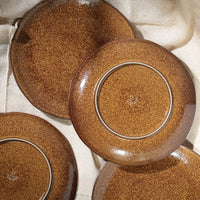 Set of brown ceramic plates on a light fabric background