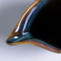 Close-up of a ceramic object with a glossy finish on a white background