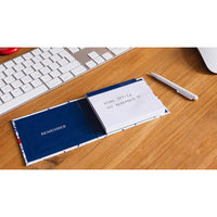 Notebook with a pen on a desk next to a keyboard