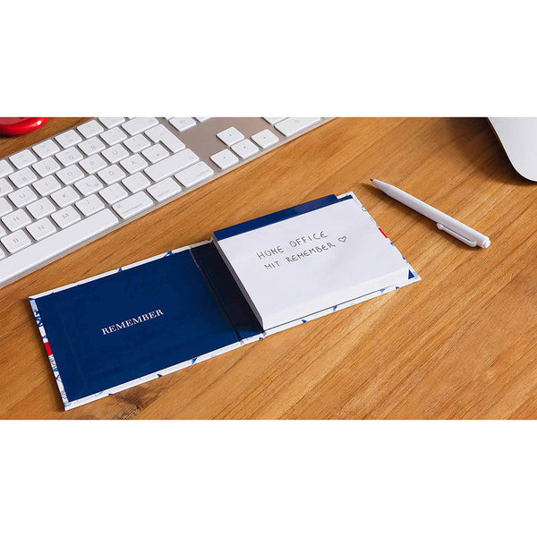 Notebook with a pen on a desk next to a keyboard