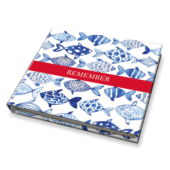 Notebook with blue fish pattern and red band on a white background