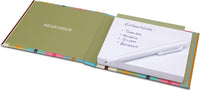 Open notebook with colorful binding and a small white sheet of paper inside.