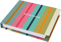Colorful striped notebook with the word 'REMEMBER' on a white background