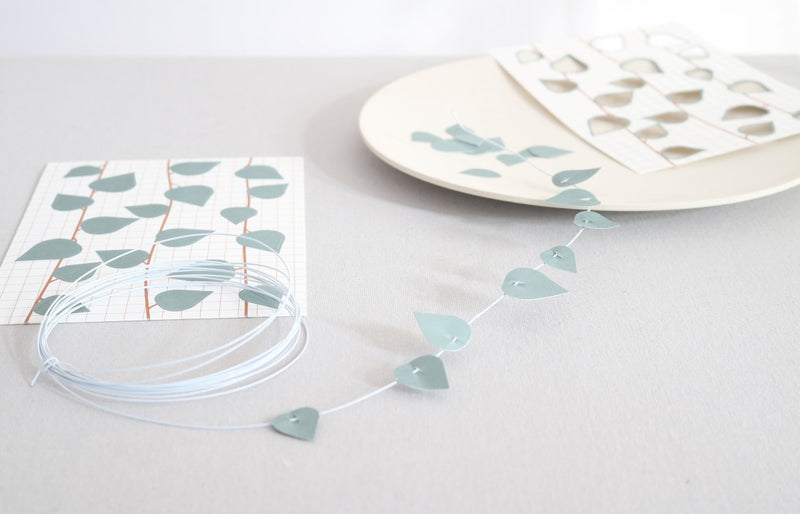 card with pre-punched leaves and metal wire on grey surface