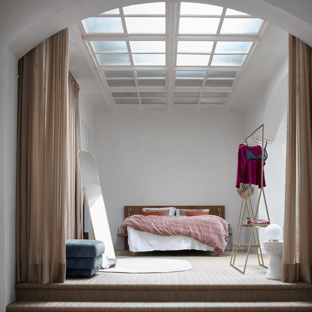 bedroom with open wardrobe and brass colored clothing hangers