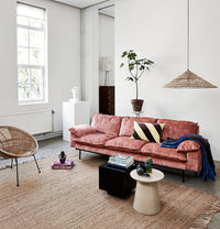 living room with velvet pink sofa and black mirror coffee table