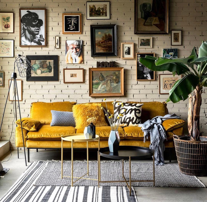 Family room with velvet ochre sofa and black and brass table