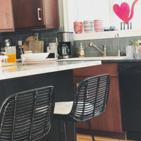 Black rattan counter stool in kitchen under island