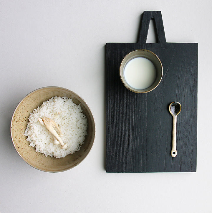 black cutting board and ceramic noodle bowl