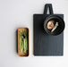 stylish black cutting board and ceramic teaspoon in tray