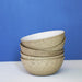 stack of ceramic egg shell bowls with a blue wall
