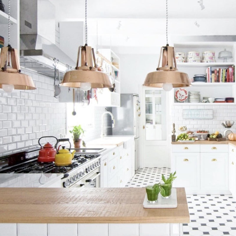 open kitchen with 3 copper workshop lamps hanging next to eachother