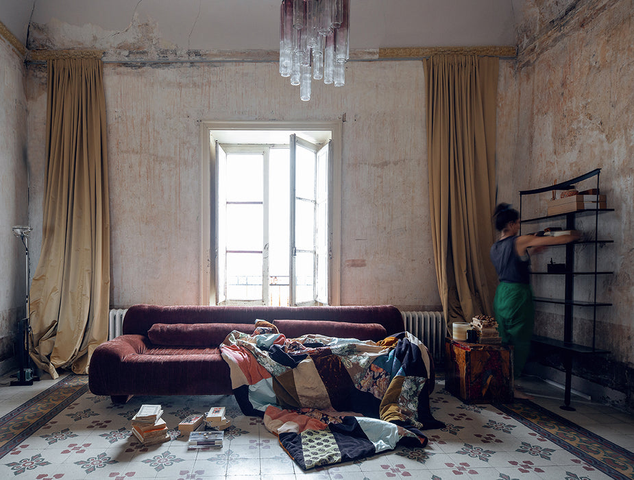 hand made patchwork throw blanket on a brick  brown retro sofa in a palazzo in Italy
