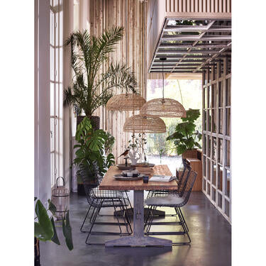 Dining room with black metal wire chairs and wicker lamp