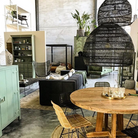 medium and xl black wicker hanging lights above a teak round dining table