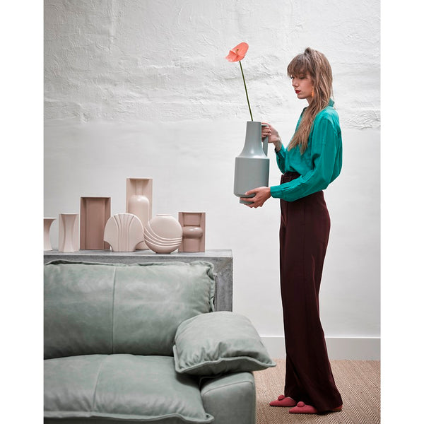 group of vases together in euth tone colors and lady in green blouse