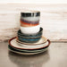 stack of ceramic plates, bowls and side plates in 70's style colors