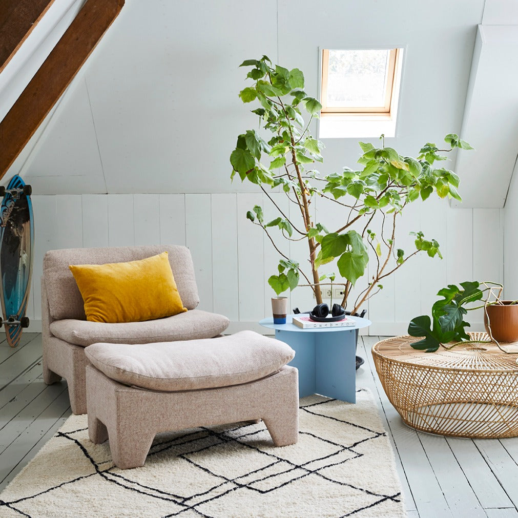 living room with pink chair and ottoman and natural wicker coffee table