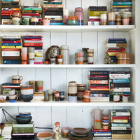 white, wooden open shelving filled with a combination of books and ceramics by HKliving