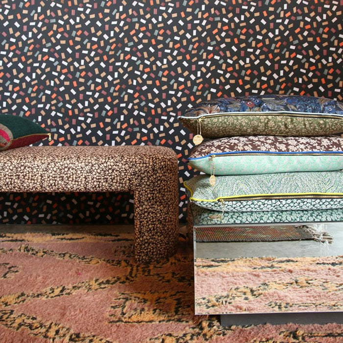 closu up picture of a stack of pillows and an upholstered bench with fabric inspired by vintage clothing