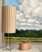 pink, yellow and brown striped table lamp on an open base with a golden electrical cord