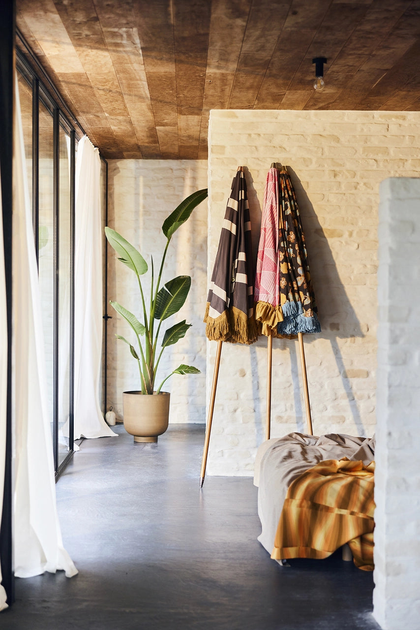 3 parasols with different fabric against a wall