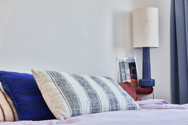 natural cotton super large pillow with wide stripes on bed with blue table lamp