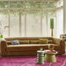 large club sofa with accent tables in various shades of green and pink area rug