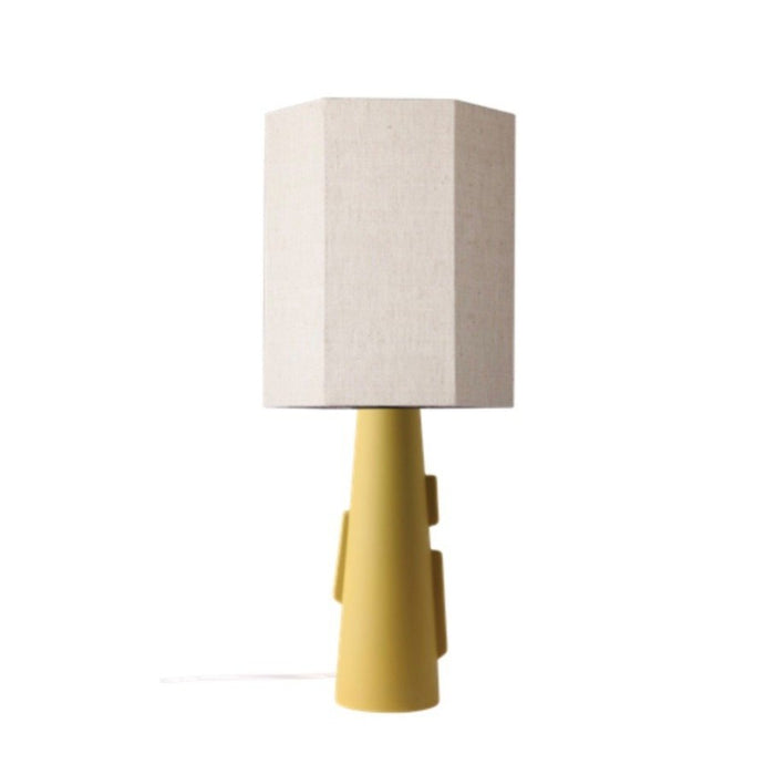yellow green-ish yable lamp made from stoneware with a hexagon shaped neutral linen shade