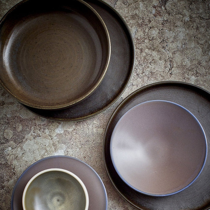 dark brown, black and purple dinner plates and bowls in bird eye view