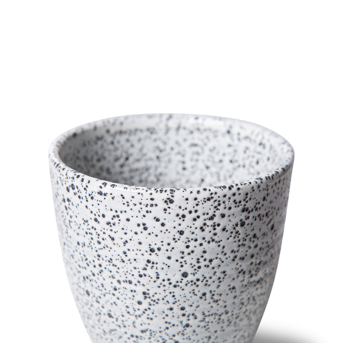 detail of white speckled stoneware tumbler mug