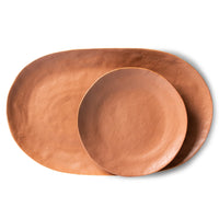 brown oval shape serving platter and same color round dinner plate