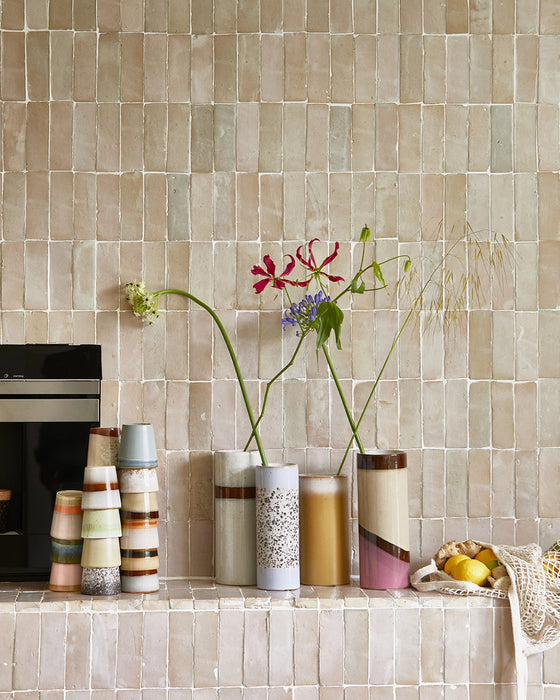beige tiles with retro style flower vases and coffee cups stacked up