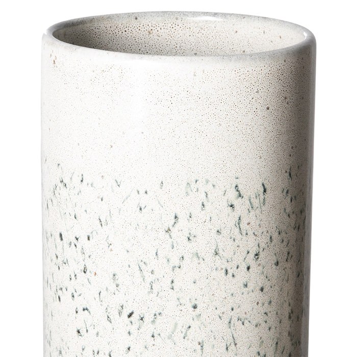 detail of tall white flower vase with dark grey greenish hail pattern