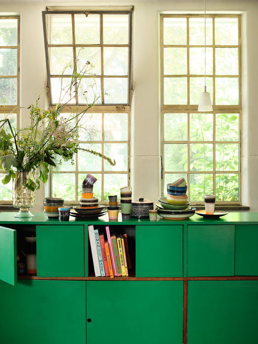 green cabinetry with retro style table ware stacked on top of each other