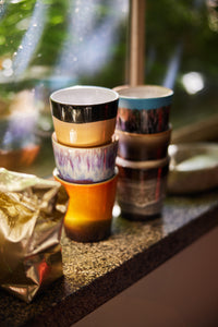 6 stoneware mugs in a window