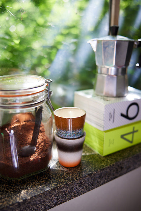 two ristretto cups next to a jar with grounded coffee