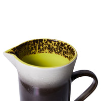 tall stoneware pitcher with orange, white and brown finish and yellow inside