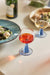 round table with linen table cloth and a red and blue stemmed wine glass