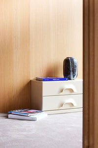 monochrome glass vase on a small drawer cabinet