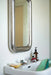 rectangular chrome chubby mirror hanging above small white sink