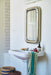 rectangular chrome chubby mirror in bathroom with blue green towel