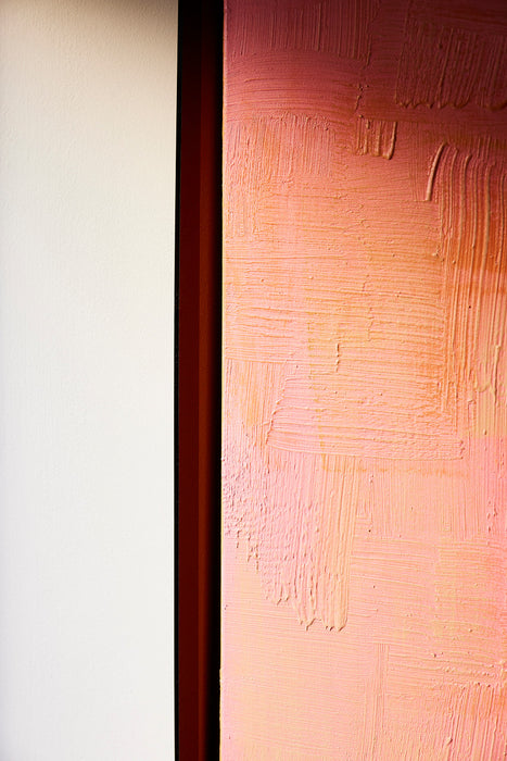 detail of paint abstract painting in pink hues with brown acrylic frame