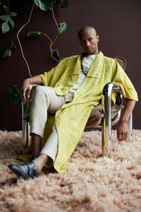 Chrome lounge armchair velvet brown with man wearing a yellow bathrobe sitting in it