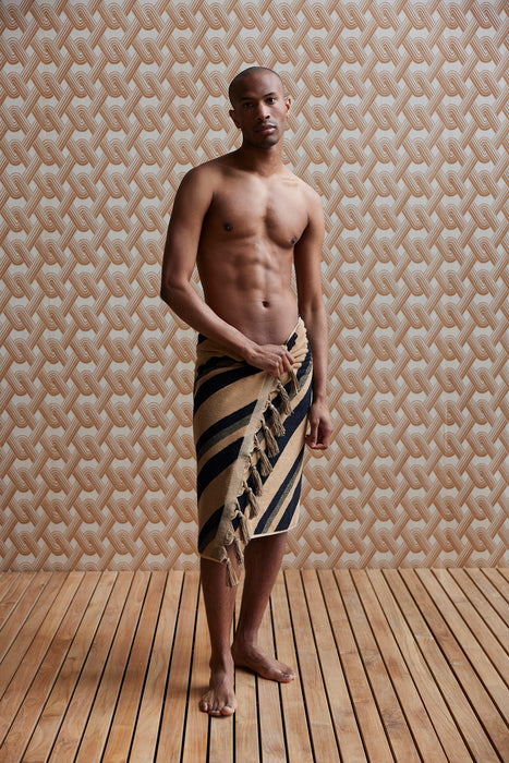 black and crème striped towel with fringes around a man's body